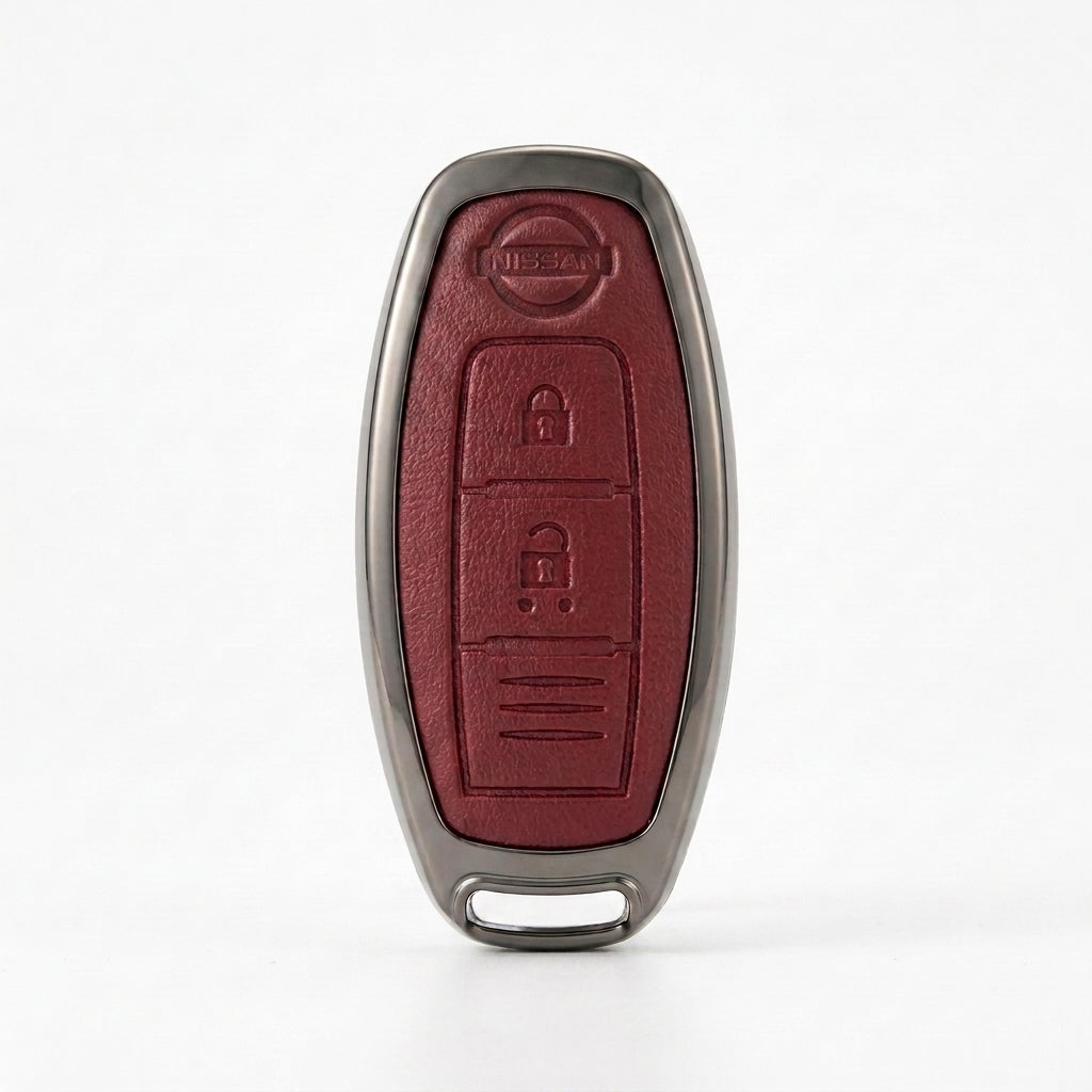 A Nissan key fob cover with a textured dark red leather center and a metallic gray border, shown on a clean white background.