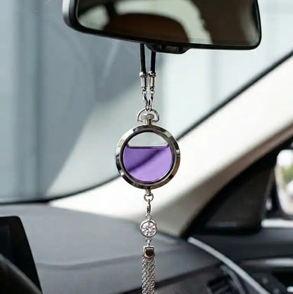 Decorative car mirror with purple center and tassel hanging from a car's rearview mirror.