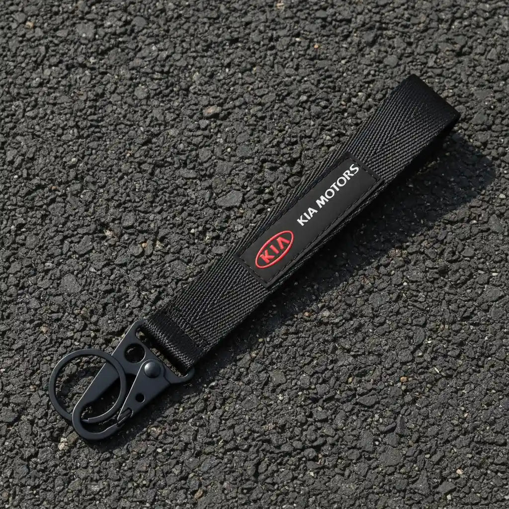 Black keychain strap with Kia Motors logo on a white background