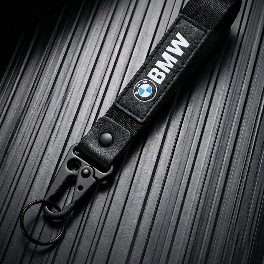 Black BMW keychain strap on a textured surface