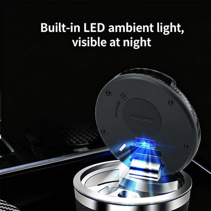 A circular car ashtray with its lid flipped open, showing a built-in LED light glowing blue in the center. White text at the top reads 'Built-in LED ambient light, visible at night' against a dark car interior background.