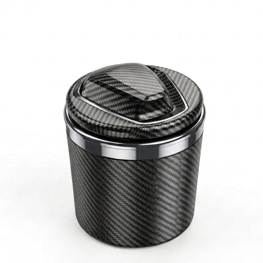 A carbon fiber textured cylindrical container with a matching lid, featuring a polished metallic silver band near the top, set against a plain white background.