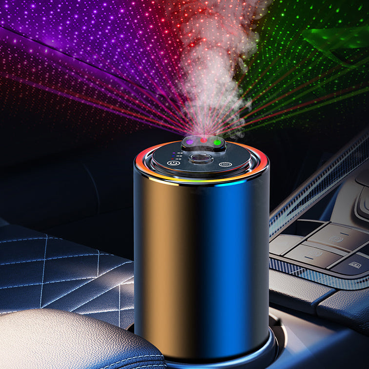 A cylindrical portable humidifier and LED projector sitting in a car cup holder, emitting white mist while projecting multicolor starry light patterns onto the car interior ceiling.