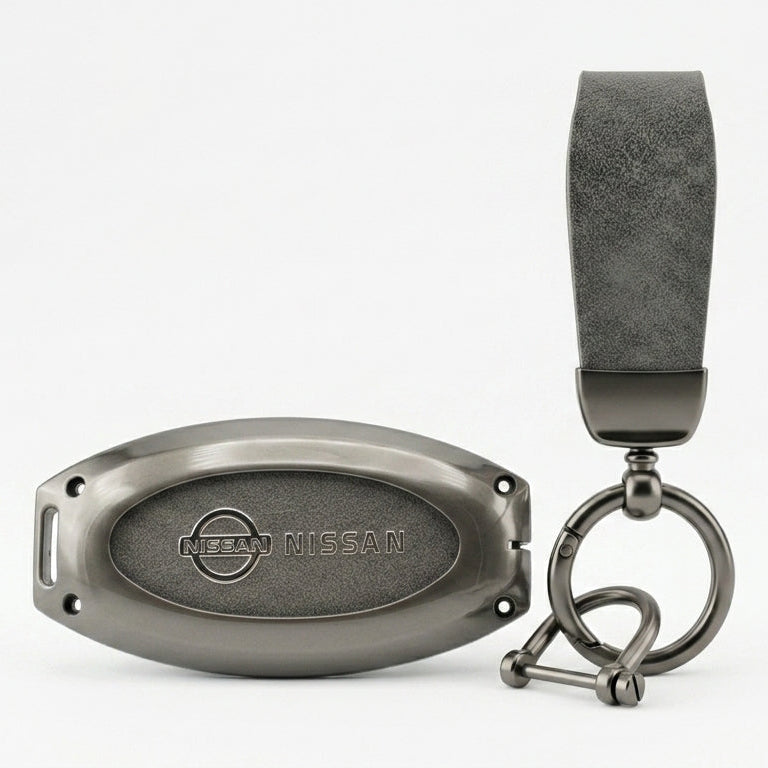 A dark gray NISSAN JUKE leather key fob cover & strap attached to a matching dark gray metal keychain ring and oval tag, shown on a clean white background.