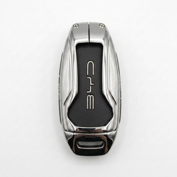 A luxury BYD METAL KEY COVER with a polished silver metallic exterior and a black textured center panel featuring the stylized BYD logo