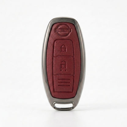 A Nissan key fob cover with a textured dark red leather center and a metallic gray border, shown on a clean white background.