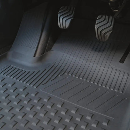 Car interior with a detailed view of the floor mat and pedals.