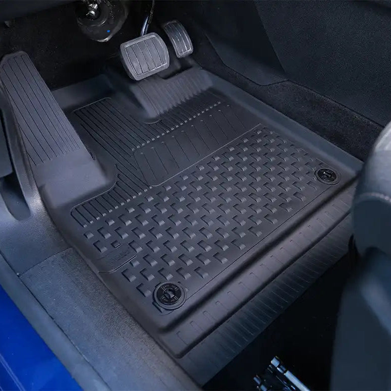 Black car floor mats with a textured pattern installed in a vehicle.